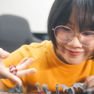 Youth playing table top role play games with miniatures and dice.