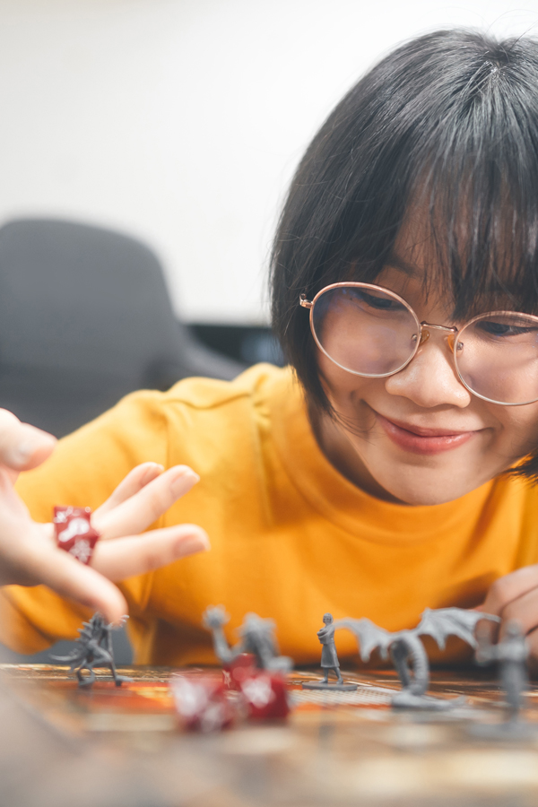 Youth playing table top role play games with miniatures and dice.